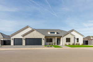 View of front facade with stone siding, a garage, a porch, and driveway