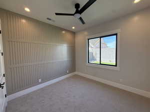 Empty room with a ceiling fan, light colored carpet, and recessed lighting