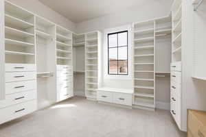 Walk in closet featuring light colored carpet