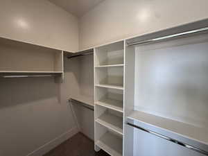 Walk in closet featuring dark carpet