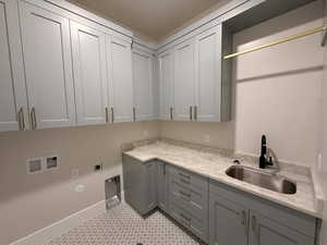 Laundry area featuring gas dryer hookup, washer hookup, cabinet space, and electric dryer hookup