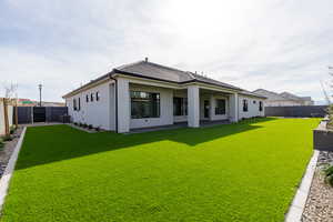 Rear view of house with a fenced backyard, a patio area, and stucco siding