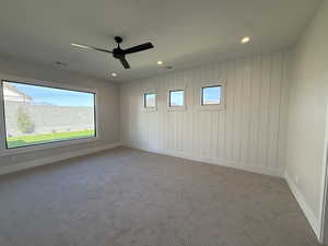 Empty room featuring carpet floors, a ceiling fan, and recessed lighting