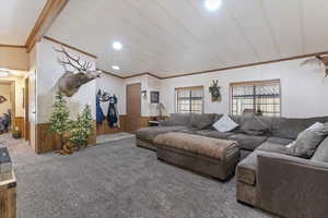 Living room with wooden walls, carpet floors, ornamental molding, recessed lighting, and wainscoting