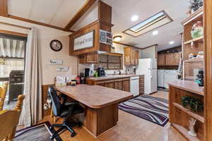 Kitchen with open shelves, lofted ceiling, wood finish cabinets, a peninsula, and crown molding