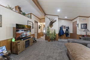 Living area featuring wood walls, wainscoting, crown molding, carpet floors, and recessed lighting