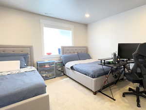 Bedroom featuring light colored carpet and an office area