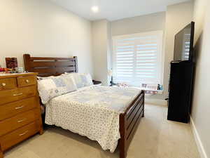 Bedroom with light colored carpet and recessed lighting