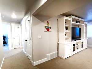 Corridor featuring light carpet and a desk