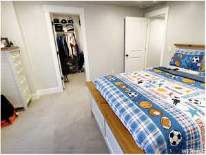 Bedroom with light carpet and a spacious closet