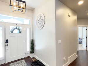 Entryway featuring dark wood-type flooring and hanging lights