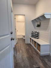 Mudroom featuring dark wood-style floors and baseboards