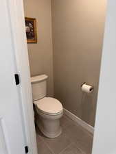 Bathroom with toilet and light tile patterned flooring