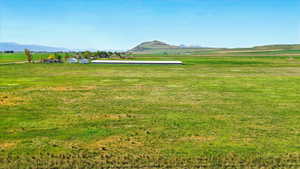View of grassy yard with a mountain view and a view of rural / pastoral area
