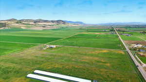 View of rural area featuring a mountainous background and extensive farmland