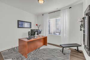 Home office with baseboards and wood finished floors