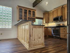 Kitchen featuring stainless steel appliances, dark wood-style flooring, vaulted ceiling with beams, glass fronted cabinets, and dark stone countertops
