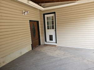 View of exterior entry with a wooden deck