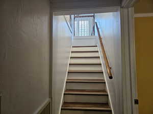 Stairway featuring a textured wall