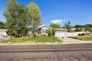 View of front of house with driveway, a garage, and a residential view