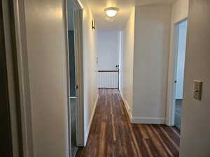 Hall with dark wood finished floors and baseboards