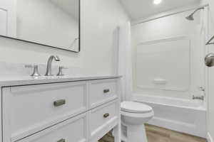 Full bathroom featuring vanity, shower / bath combination with curtain, and light wood finished floors