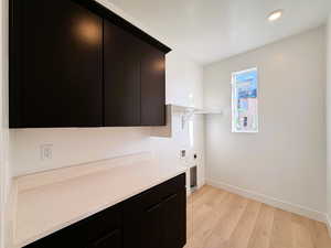 Laundry area featuring hookup for an electric dryer, light wood-style floors, cabinet space, hookup for a washing machine, and recessed lighting