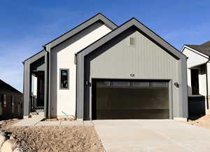 View of front of property featuring concrete driveway and a garage