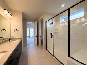 Bathroom with a stall shower, double vanity, light tile patterned flooring, and recessed lighting