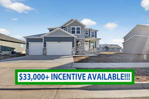Craftsman-style house with stone siding, a porch, concrete driveway, an attached garage, and board and batten siding
