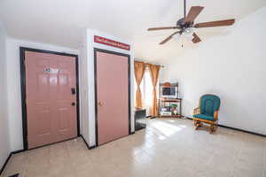 Foyer entrance with ceiling fan, lofted ceiling, and light tile patterned floors