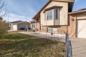 Back of house featuring brick siding, a patio, and a garage