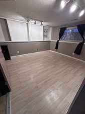 Empty room with rail lighting and a textured ceiling