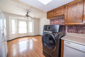 Laundry area with washer / clothes dryer, light wood finished floors, and ceiling fan