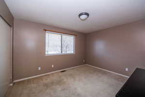 Unfurnished room featuring light carpet and a textured ceiling