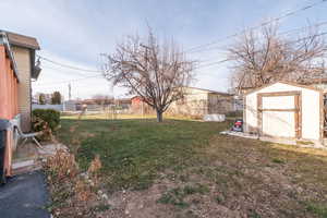 Fenced backyard featuring a storage shed