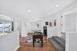 Virtually staged as a game room with recessed lighting, wood finished floors, vaulted ceiling, and electric panel