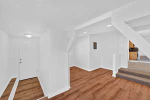 Entryway with stairs and wood finished floors