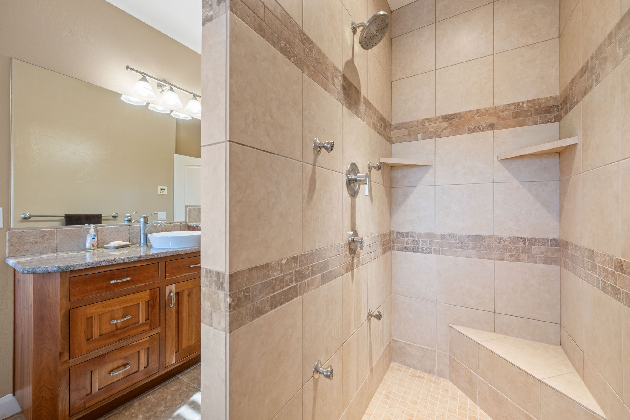 Full bathroom featuring a tile shower and vanity