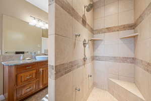 Full bathroom featuring a tile shower and vanity