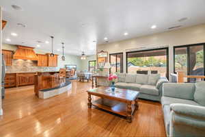 Living area featuring ceiling fan, light wood finished floors, and recessed lighting