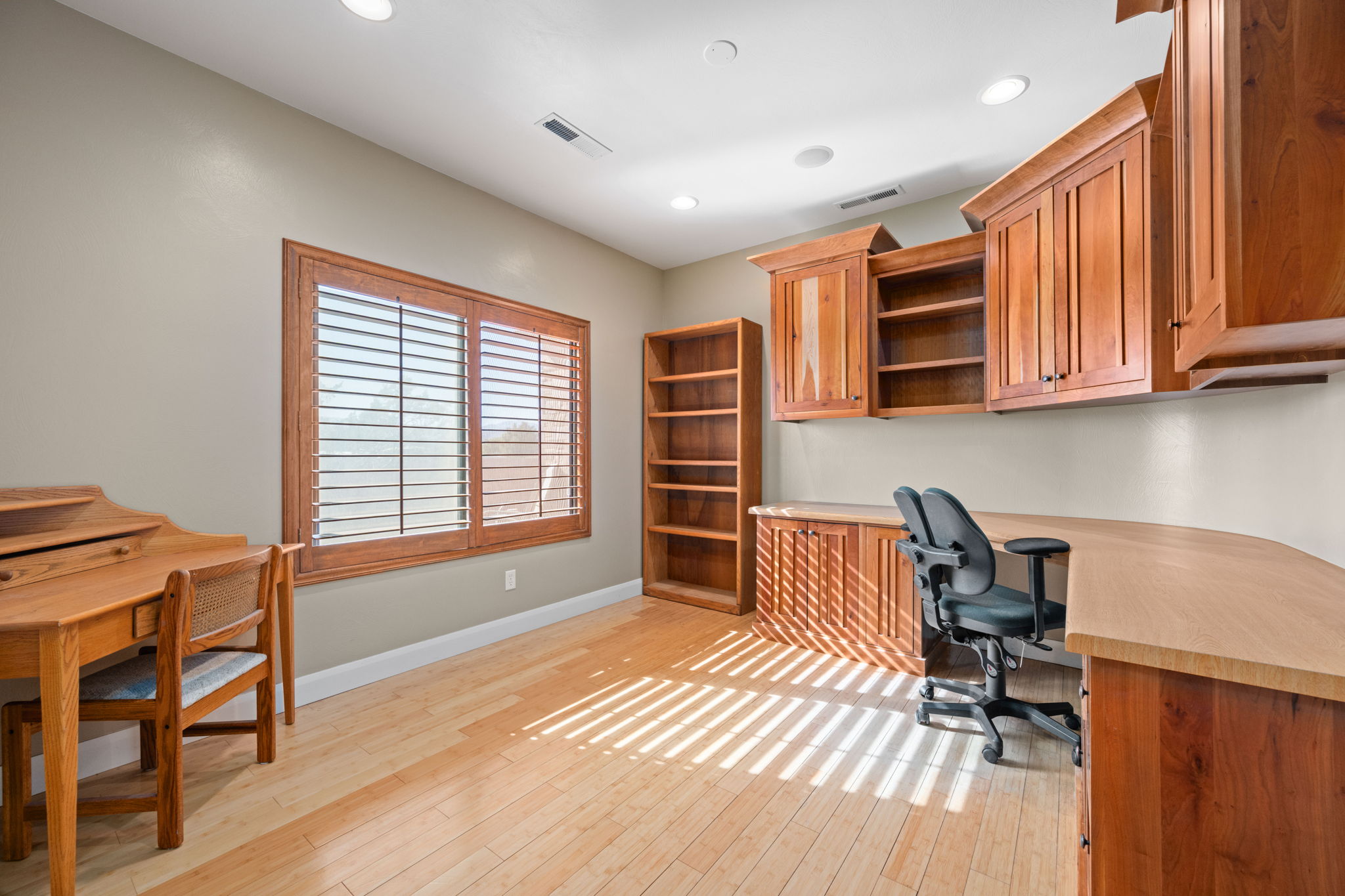 Home office with built in desk, light wood-style floors, and recessed lighting
