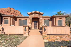 Mediterranean / spanish home featuring stone siding, a fenced front yard, and stucco siding