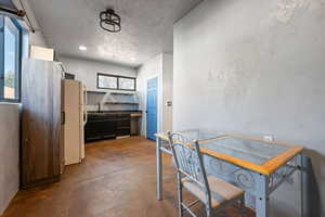 Dining space with concrete flooring, a textured ceiling, and recessed lighting