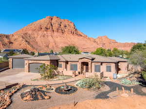 View of front of home featuring stone siding, a mountain view, concrete driveway, and an attached garage