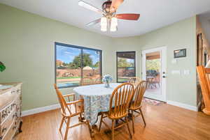Dining area with light wood-style flooring and ceiling fan