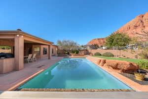 View of swimming pool featuring patio surround, a fenced backyard, and a mountain view