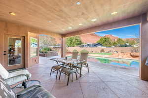 Fenced backyard featuring a mountain view, a patio, and outdoor dining space