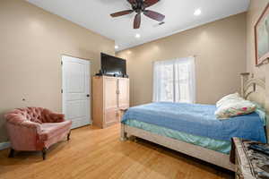 Bedroom with light wood-style flooring, a ceiling fan, and recessed lighting