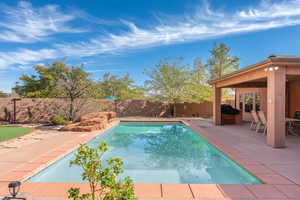 View of pool featuring patio surround and a fenced backyard